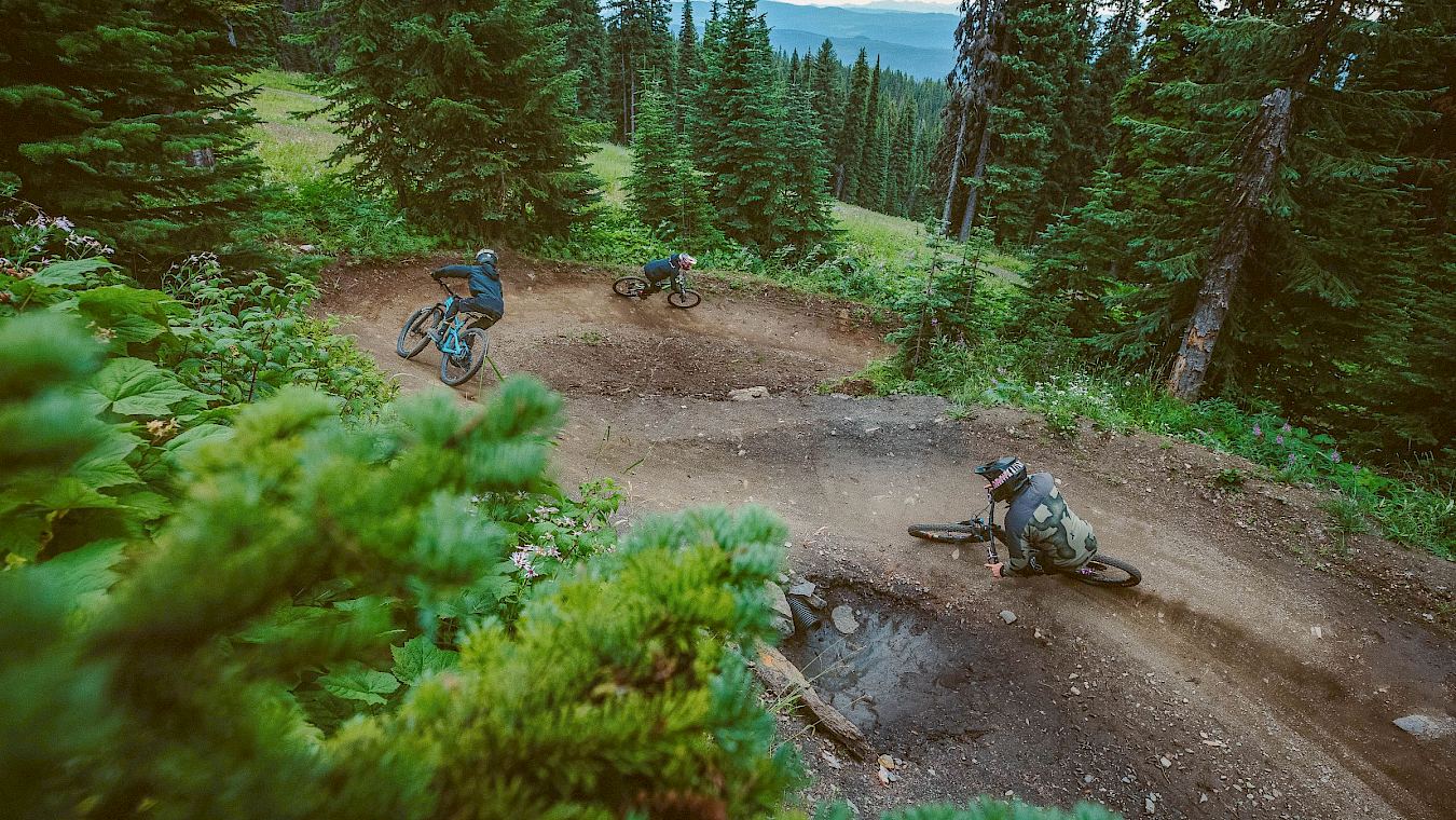 two mountain bikers riding trails with berms and jumps