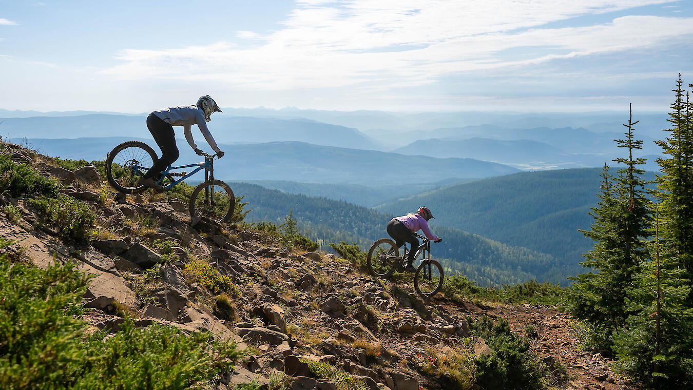 mountain bikers riding down a rocky slope