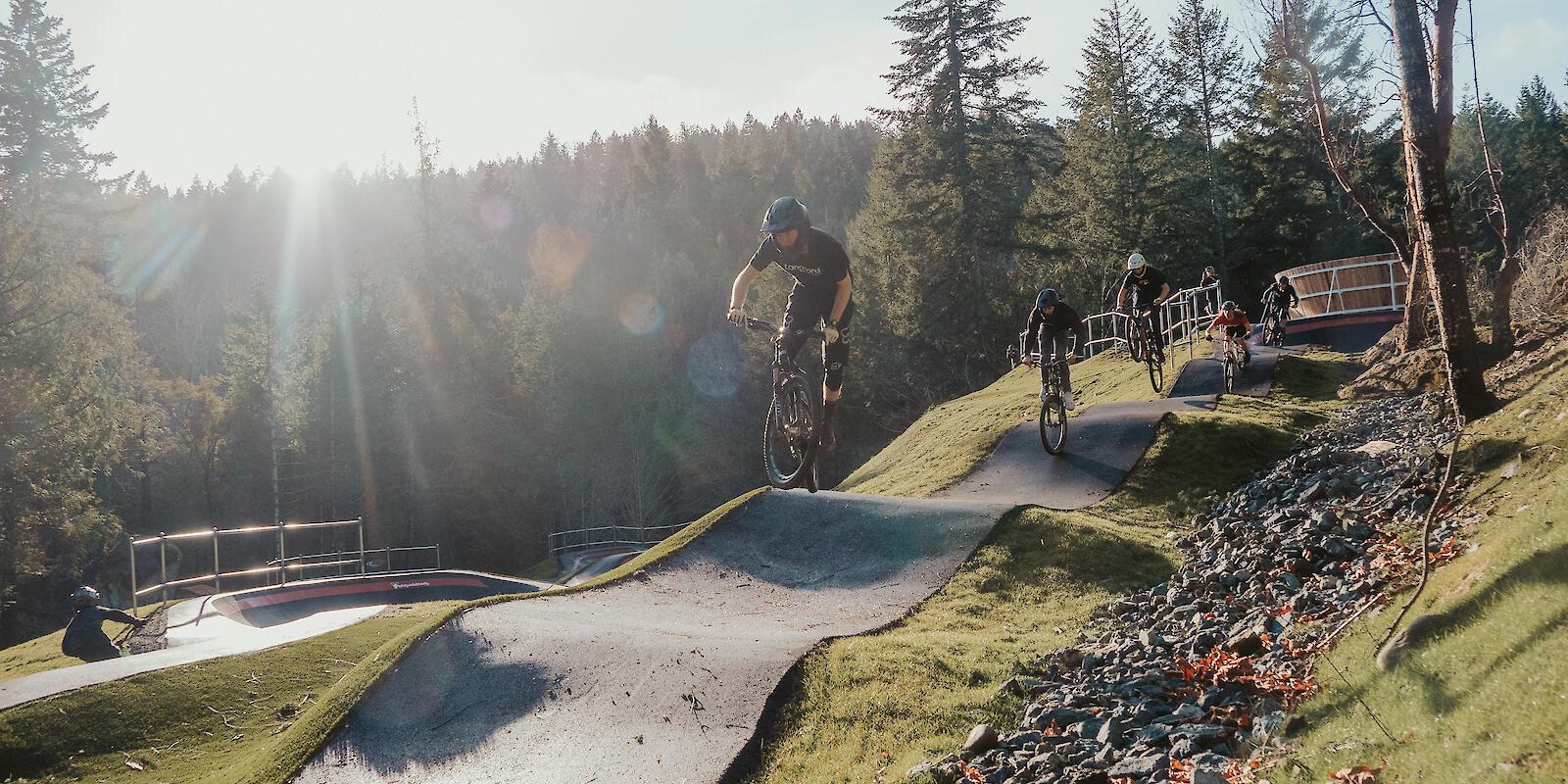 Riders rolling through paved pump track in Lanford on Vancouver Island